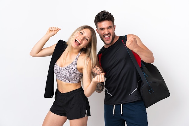 Young sport couple isolated on white background celebrating a victory