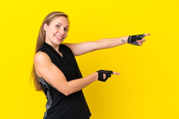 Young sport English woman isolated on white background pointing finger to the side and presenting a product