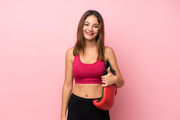 Young sport girl over isolated pink  with boxing gloves