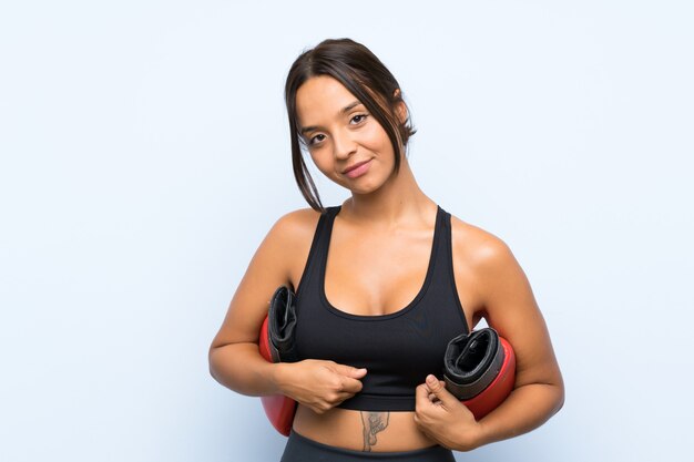 Young sport girl with boxing gloves over isolated blue wall