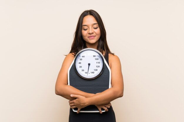 Young sport girl with weighing machine 