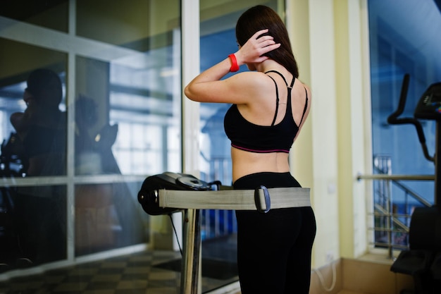 Young sport girl workout in gym Fitness woman doing exercises Sexy ass at anticellulite massager simulator