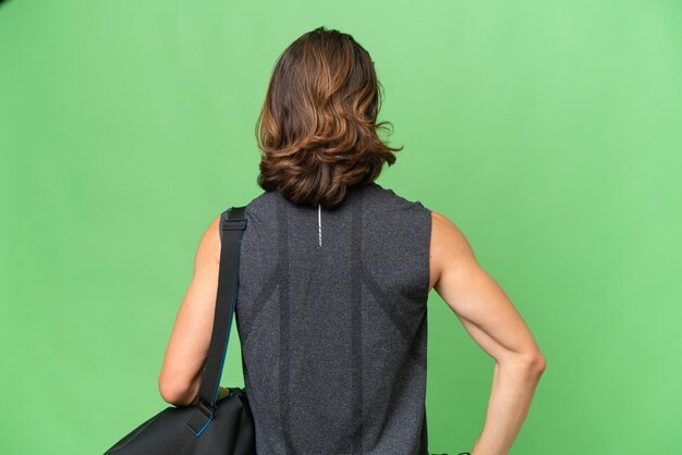 Young sport handsome man isolated on green chroma background in back position