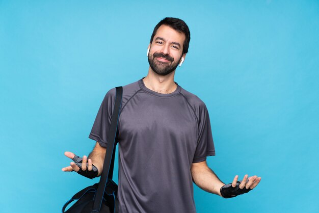 Young sport man with beard over isolated blue smiling