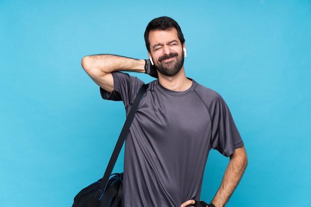 Young sport man with beard over isolated blue with neckache