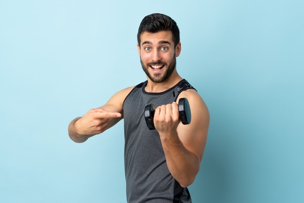 Young sport man with beard making weightlifting and pointing it