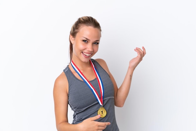 Young sport Russian girl with medals isolated on white background making guitar gesture