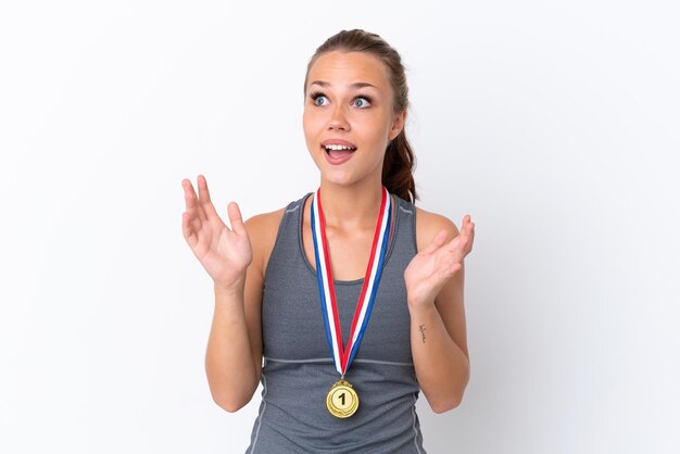 Young sport Russian girl with medals isolated on white background with surprise facial expression