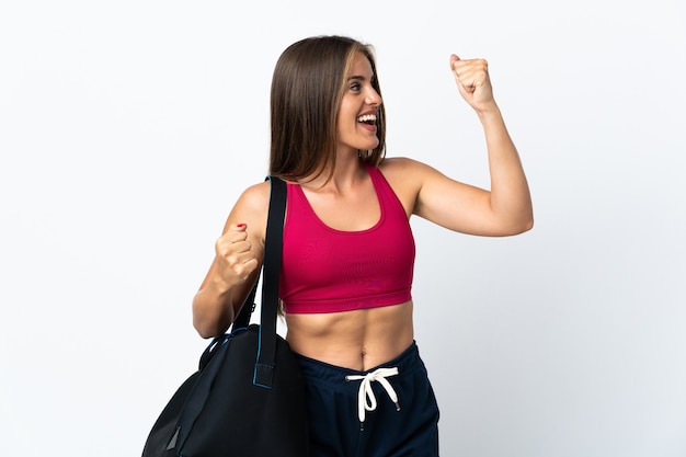 Young sport Uruguayan woman with sport bag isolated on white background celebrating a victory