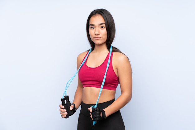 Young sport woman on blue with jumping rope