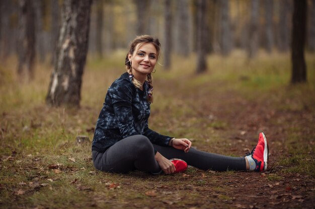 Young sport woman doing leg stretching leg before running