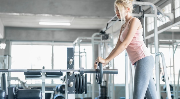 Young sport woman exercise at fitness gym caucasian girl\
workout indoors concept of sport healthcare medical and beauty\
shape