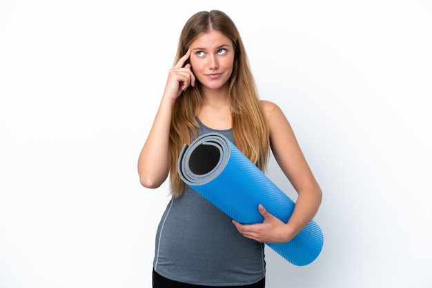 Young sport woman going to yoga classes while holding a mat having doubts and thinking