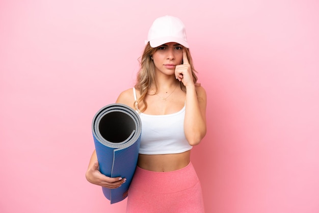 Young sport woman going to yoga classes while holding a mat thinking an idea