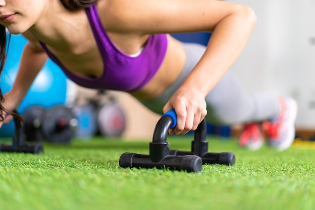 Young sport woman in a gym doing push-ups