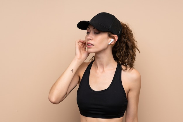Young sport woman over isolated  listening music