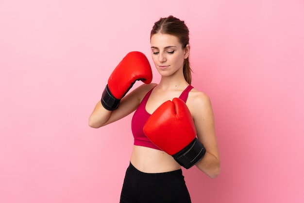 Young sport woman over isolated pink wall with boxing gloves