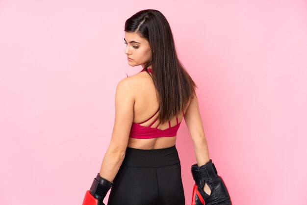 Young sport woman over isolated pink with boxing gloves