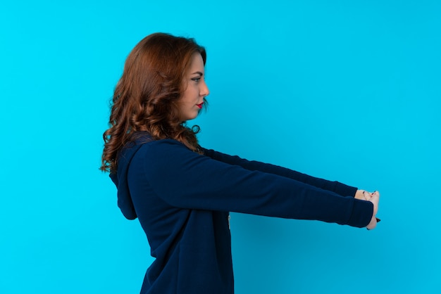 Young sport woman over isolated wall