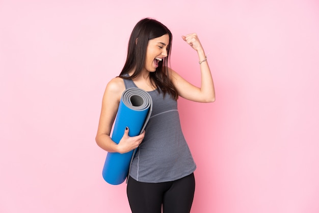 Young sport woman over isolated wall