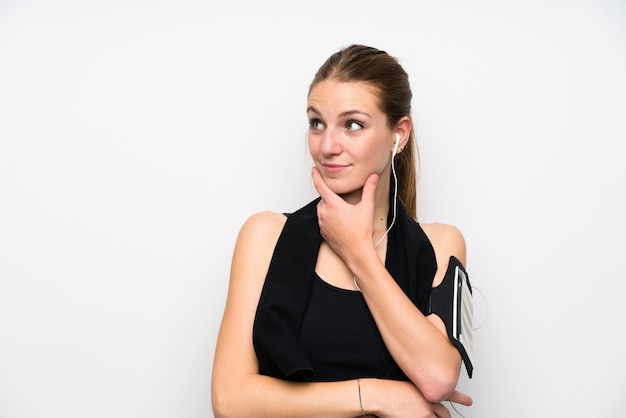 Young sport woman over isolated white wall thinking an idea