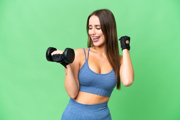 Young sport woman making weightlifting over isolated chroma key background celebrating a victory