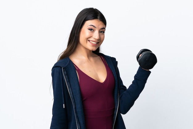 Young sport woman making weightlifting over isolated white wall smiling a lot