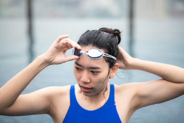 Young sport woman person swimming in water pool, healthy female people in blue swimwear with athlete lifestyle, underwater active fitness competition girl with goggles in swimming pool