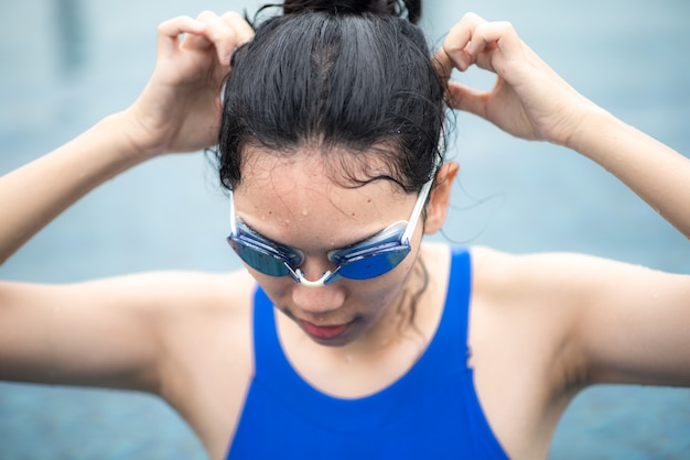 水プールで泳ぐ若いスポーツ女性の人、アスリートのライフスタイルを持つ青い水着の健康な女性、プールでゴーグルと水中アクティブフィットネス競争の女の子