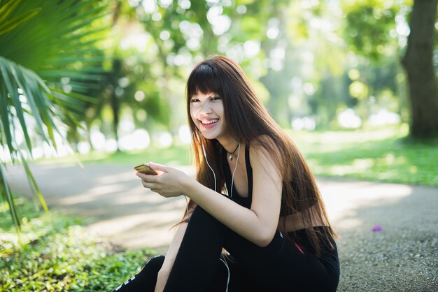 Young sport woman using mobile in the park