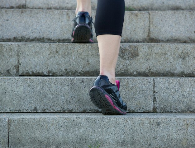 Giovane donna sportiva che cammina di sopra in scarpe da ginnastica