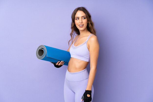 Young sport woman with a mat