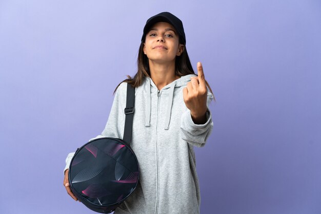 Young sport woman with sport bag doing coming gesture