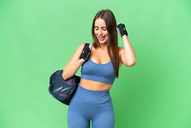 Giovane donna sportiva con borsa sportiva su sfondo chroma key isolato che celebra una vittoria