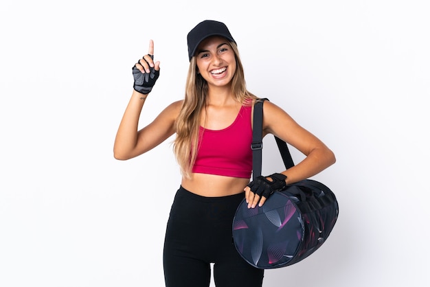 Young sport woman with sport bag over isolated white pointing up a great idea