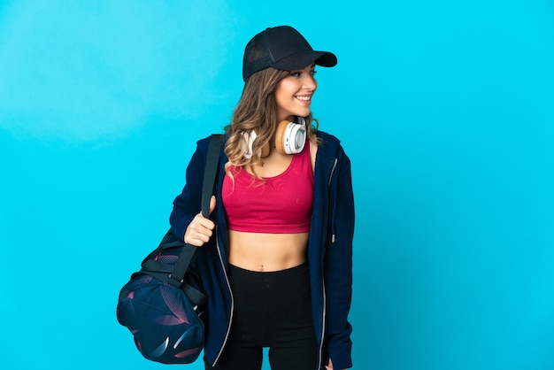 Photo young sport woman with sport bag posing isolated against the blank wall