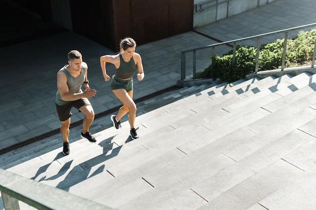 Young sportive couple during workout stair running outdoors