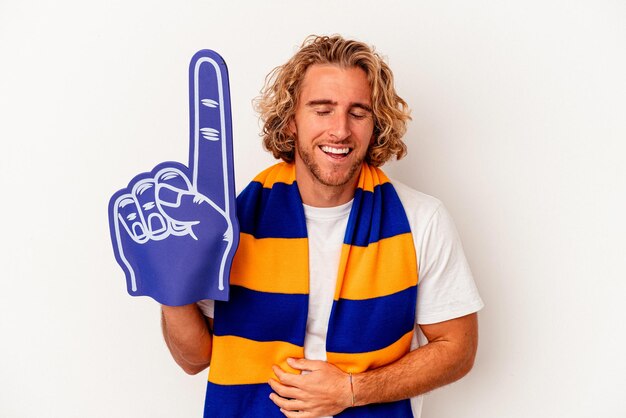 Young sports caucasian fan man isolated on white background laughing and having fun.