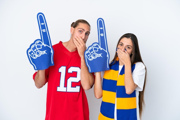 Young sports fan couple isolated on white background covering mouth with hands for saying something inappropriate