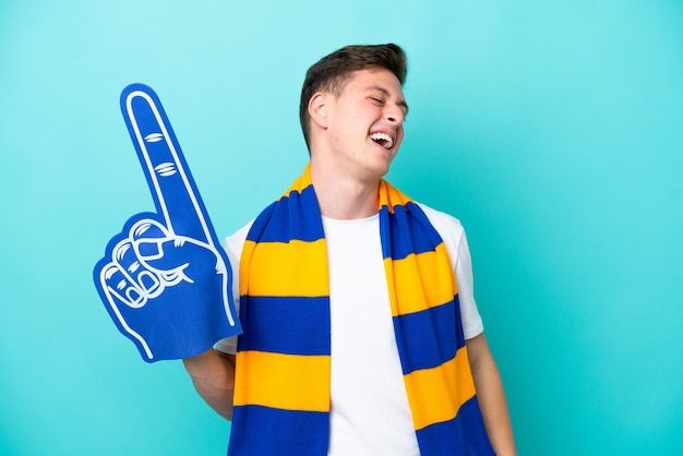 웃는 파란색 배경에 고립 된 젊은 스포츠 팬 남자