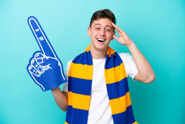 놀람 표정으로 파란색 배경에 고립 된 젊은 스포츠 팬 남자