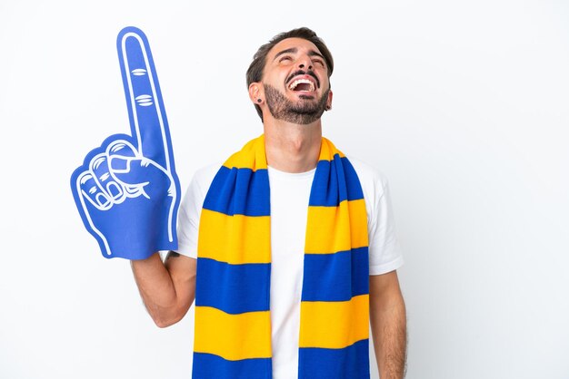 Young sports fan man isolated on white background laughing