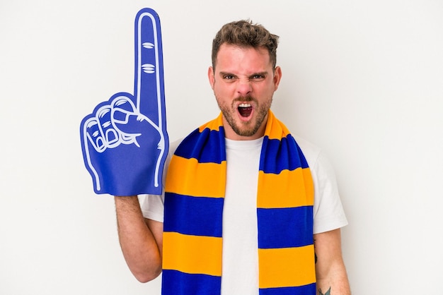 Young sports fan man isolated on white background screaming very angry and aggressive.