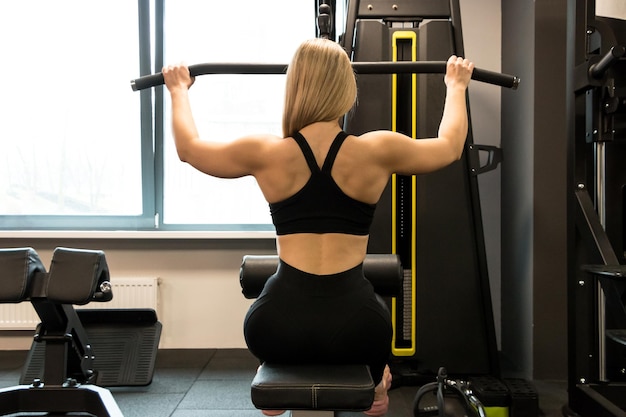 La giovane ragazza sportiva in abbigliamento sportivo fa esercizi in palestra