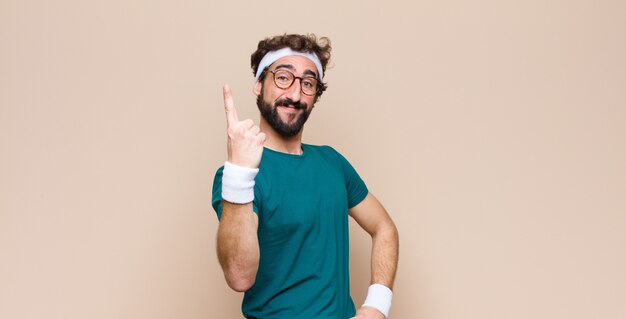 Young sports man expressing a concept against flat wall