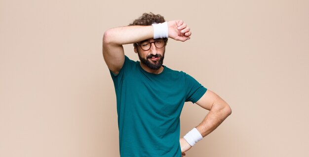 Young sports man expressing a concept against flat wall