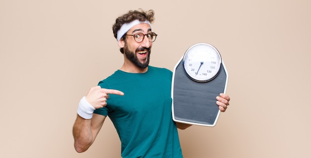 Young sports man with a scale.