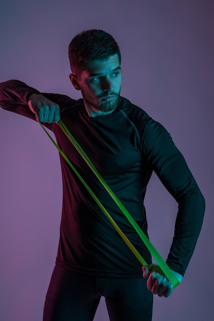 Young sportsman posing with resistance loop band