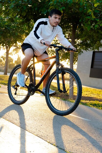 Photo young sportsman riding bicycle in the morning