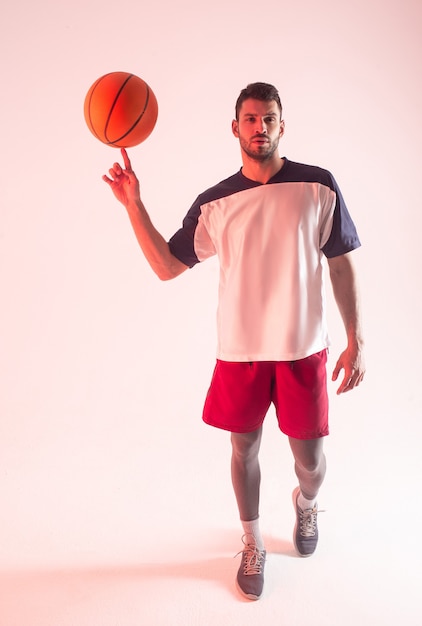 Young sportsman spinning basketball ball on finger